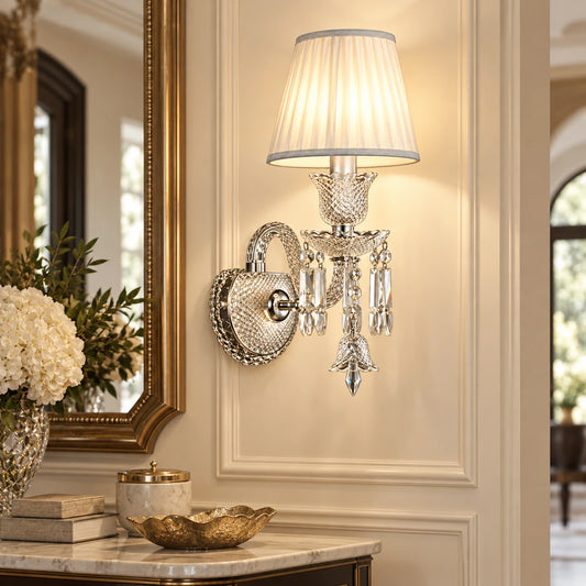 Crystal accent wall sconce beside an entryway console and mirror