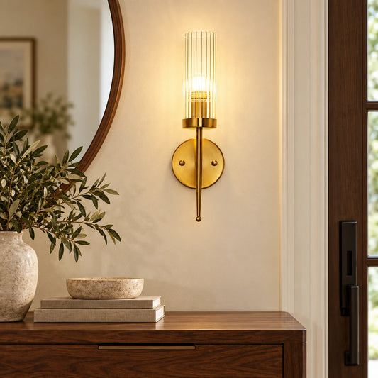 Ribbed glass cylinder wall sconce in a warm entryway