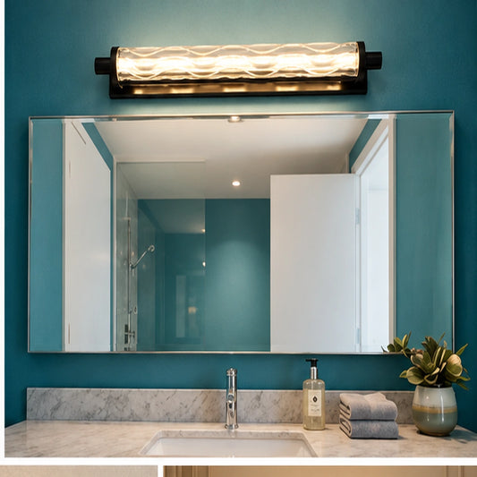 Black faceted glass linear mirror light above a bathroom mirror