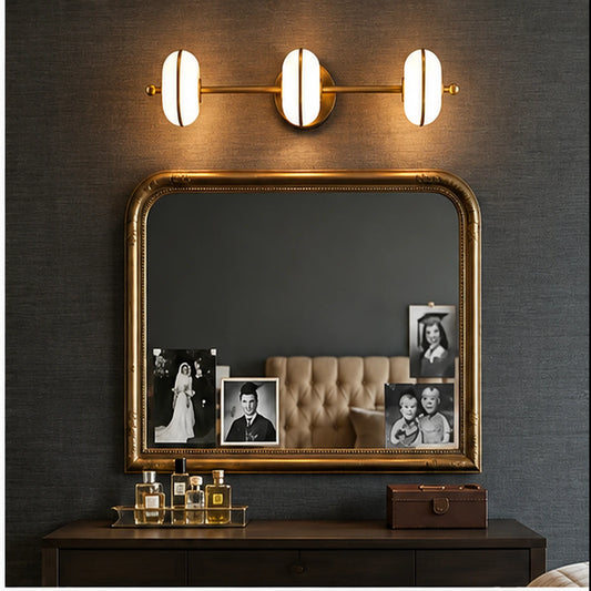 Three-light vanity bar above a dressing mirror
