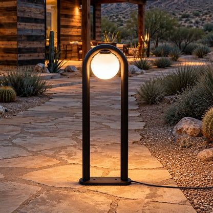 Arched globe matte-black LED bollard beside a landscaped garden path