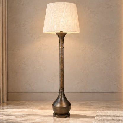 Antique-bronze column floor lamp illuminated in a contemporary living room