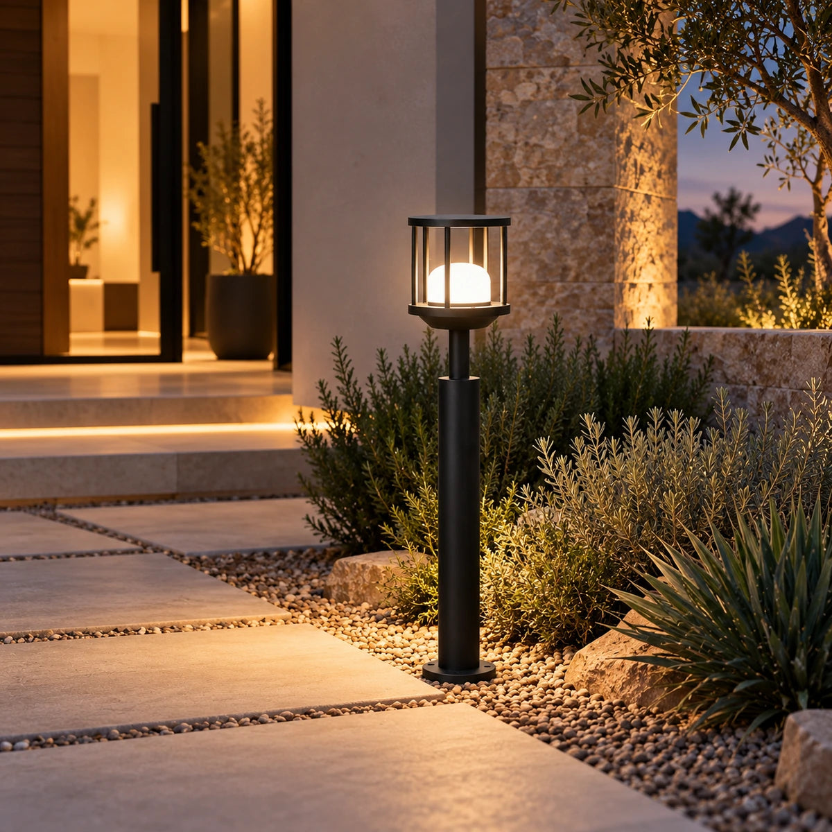 Caged dome matte-black LED bollard illuminated at a villa entrance