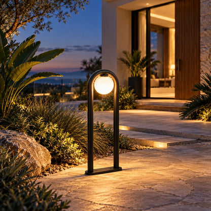 Arched globe matte-black LED bollard illuminated at a villa entrance