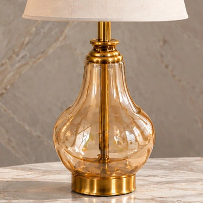 Close-up of the transparent amber glass body and gold stem