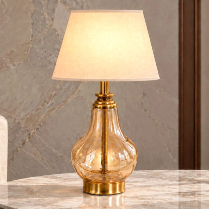 Amber glass table lamp illuminated in a neutral interior