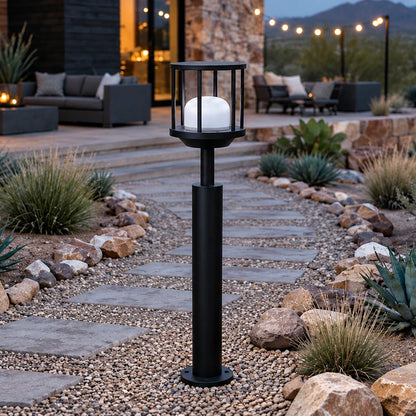 Caged dome matte-black LED bollard unlit beside a garden path