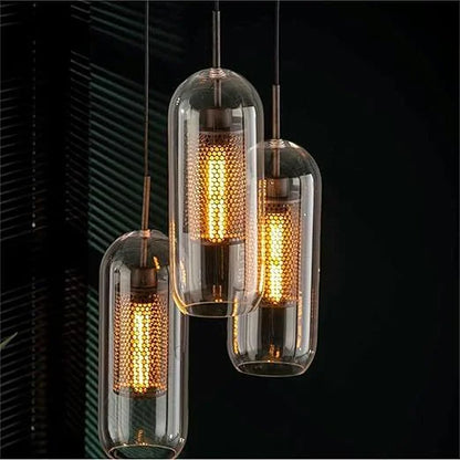 Three luxe capsule mesh pendants in a dark dining setting