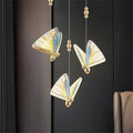 Three butterfly mosaic pendants beside a window
