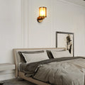 Cylindrical glass wall sconce in a bedroom