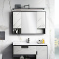 Black adjustable mirror light above a vanity mirror