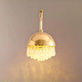 Crystal fringe dome wall sconce illuminated on a wall