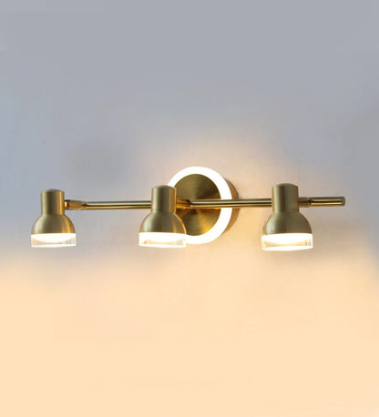Golden triple-head vanity light illuminated on a wall