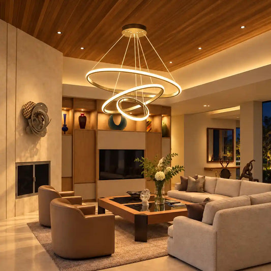 A modern multi-ring LED chandelier with a warm white glow hangs in a contemporary living room with beige furniture, a wood ceiling, and built-in shelving.