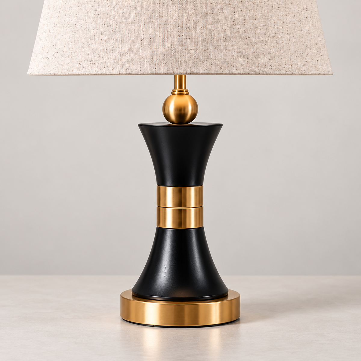 Hourglass black body and twin gold-tone centre bands with round gold-tone base