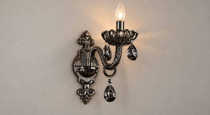 Black ornate single-arm wall light with hanging accents