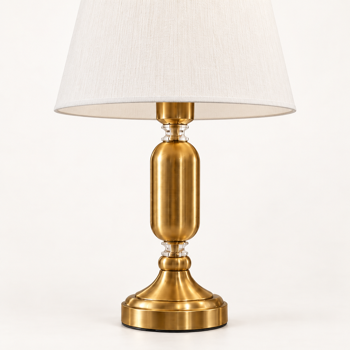 Close view of the Elara table lamp brass-tone body, clear spacers and stepped base
