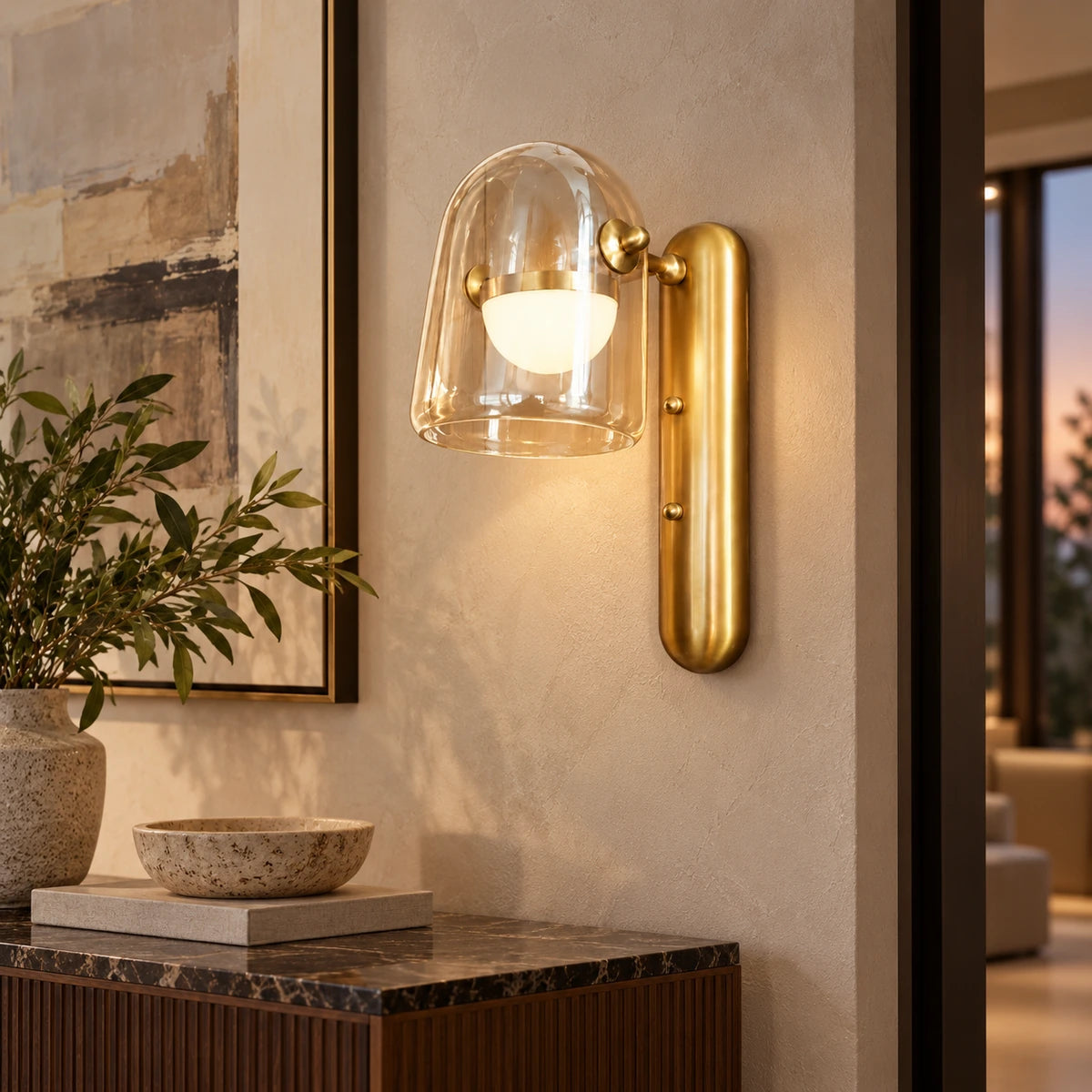 Clear glass and brushed-gold wall light in a hallway