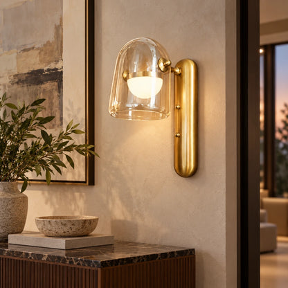 Clear glass and brushed-gold wall light in a hallway