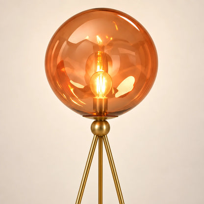 Close-up of translucent amber glass globe and tripod connection
