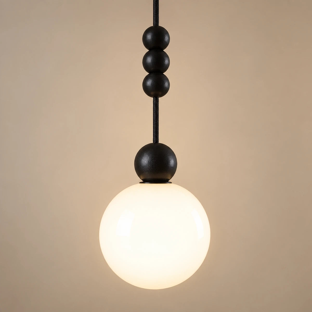 Close-up of the matte black beads, cord and white glass globe