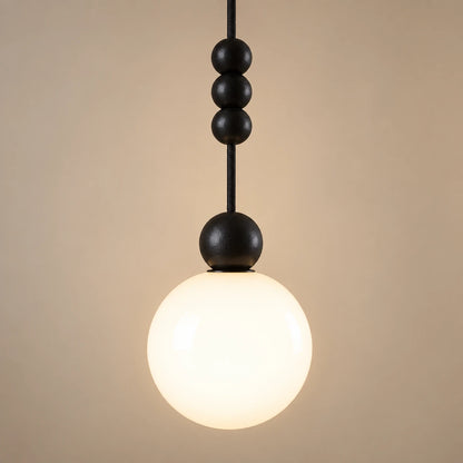 Close-up of the matte black beads, cord and white glass globe