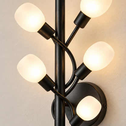 Close-up of five frosted globes, black holders, curved branches and round backplate