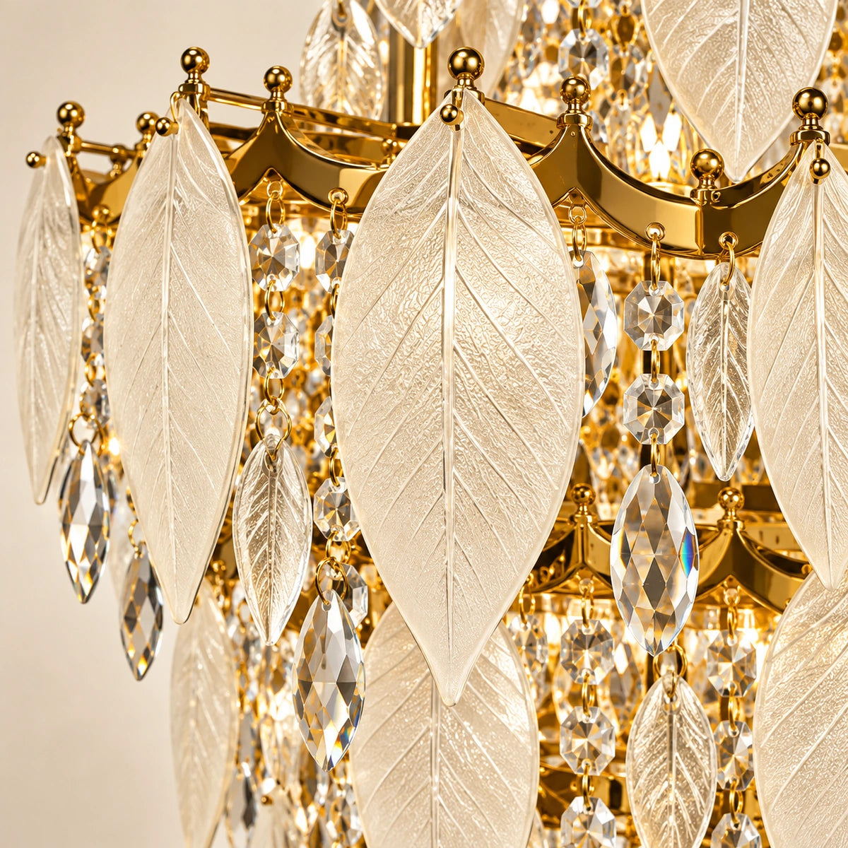 Close-up of frosted veined glass leaves, clear faceted drops and gold attachments