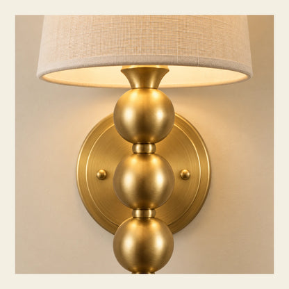 Close-up of woven shade, gold cap, wall plate and graduated beads