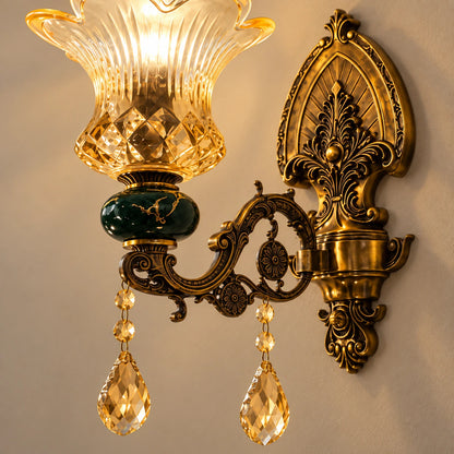 Close-up of the amber glass shade, green accent and antique-brass scrollwork