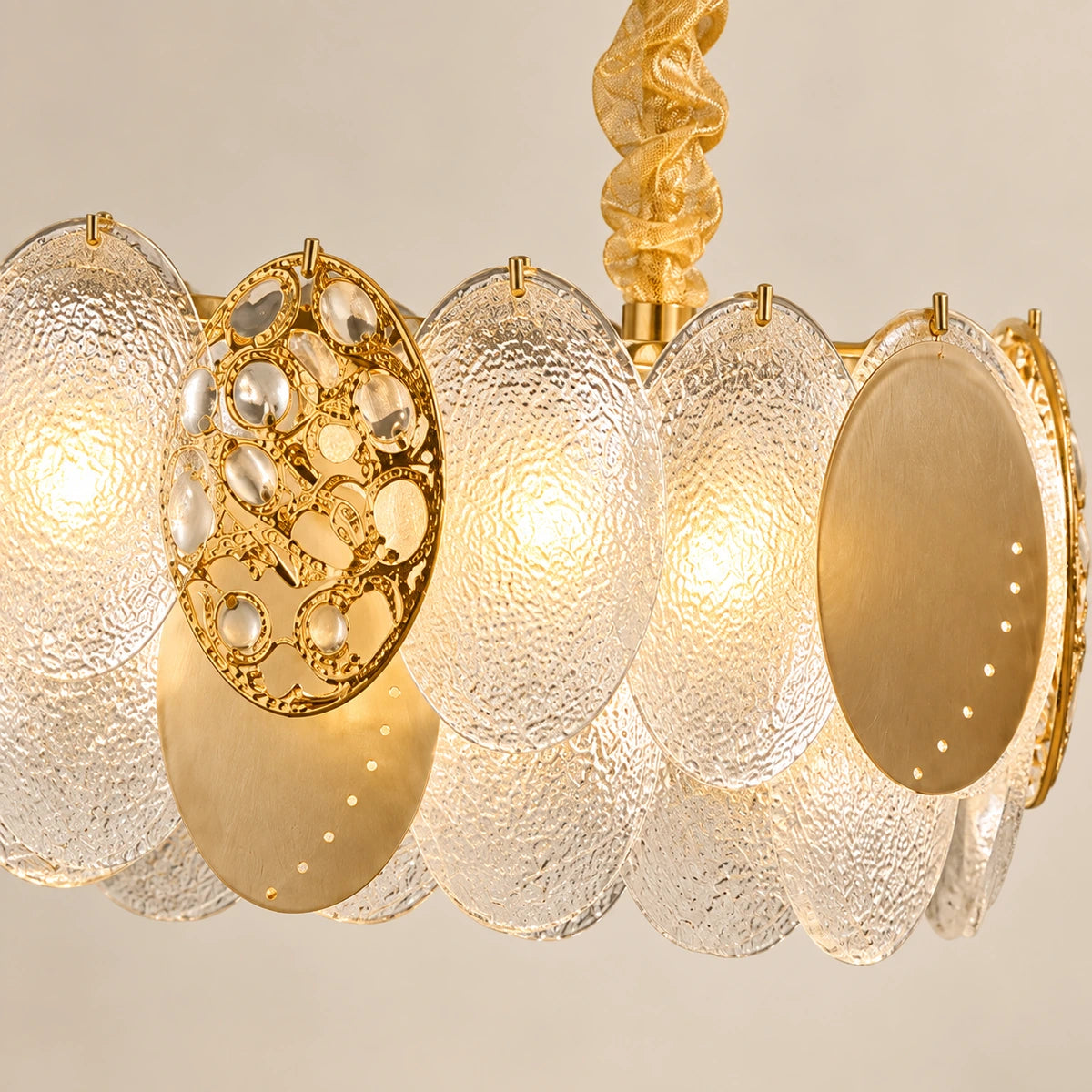 Close-up of textured glass discs, gold-tone accents and suspension attachment