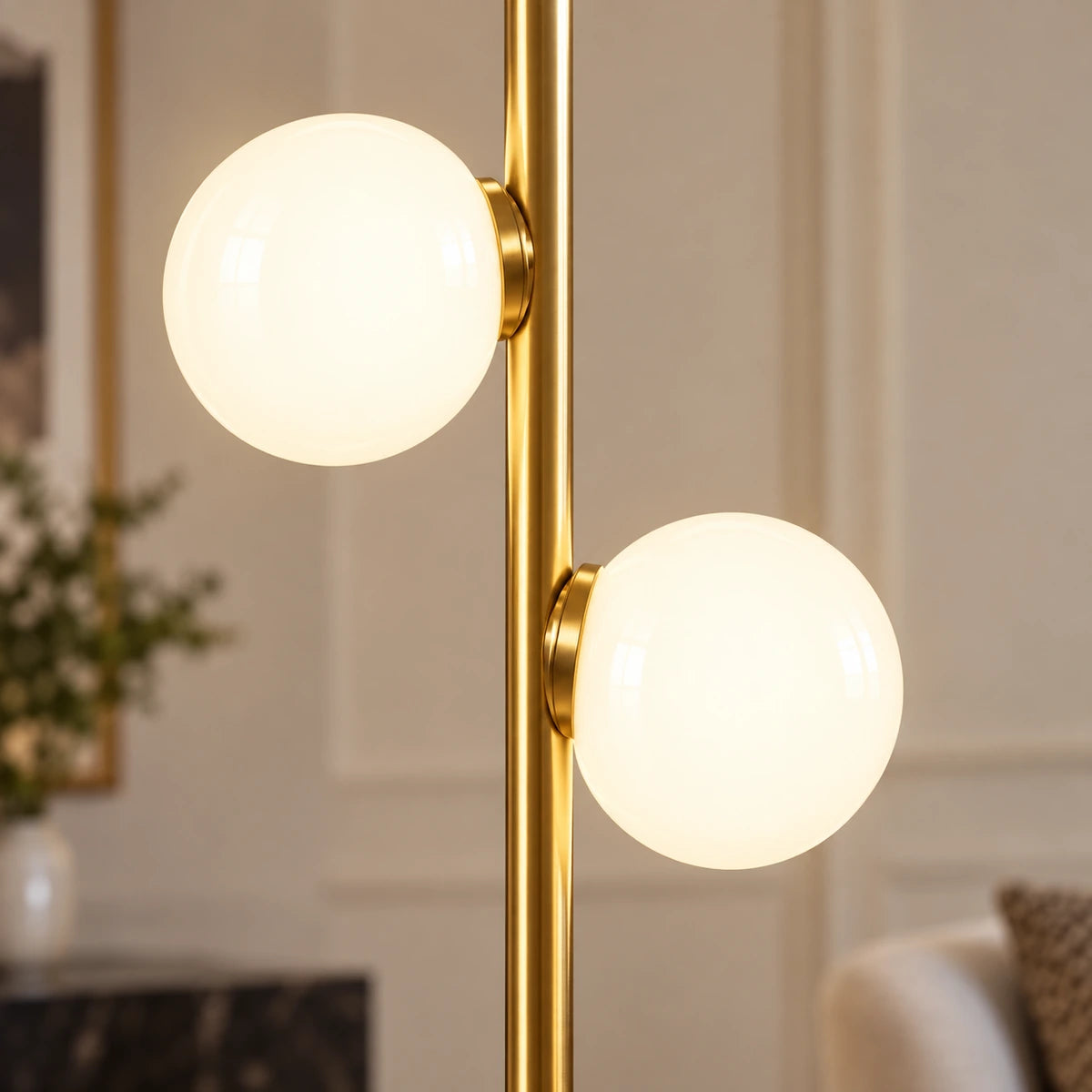 Close-up of two milky globes and their gold-tone rail attachments