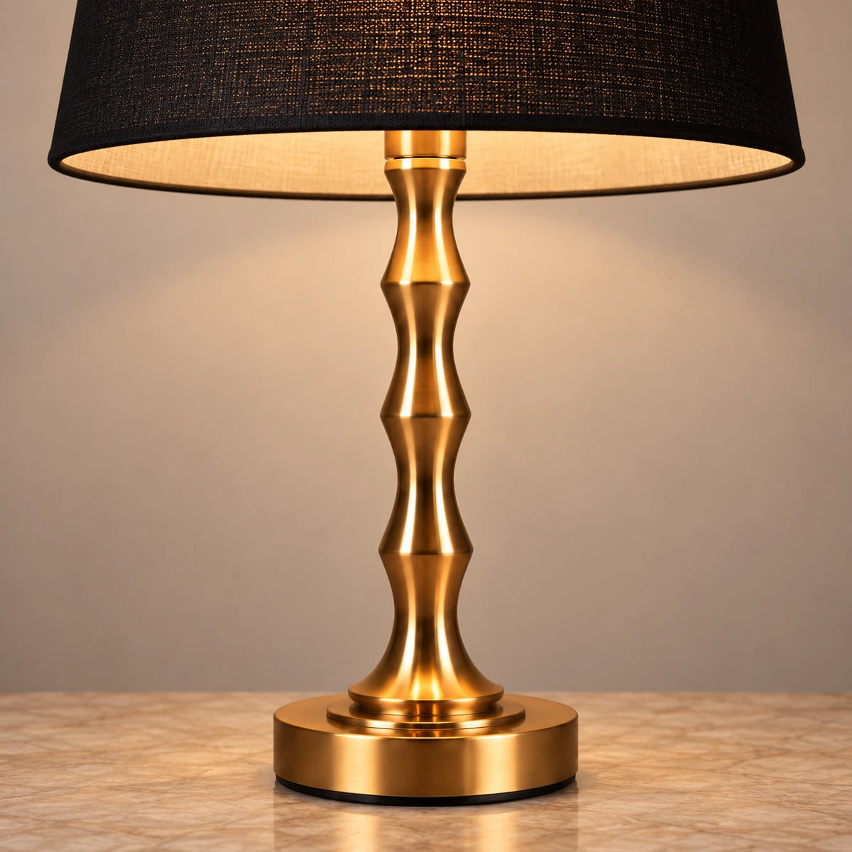 Close-up of the black fabric shade, copper-tone stem and stepped base