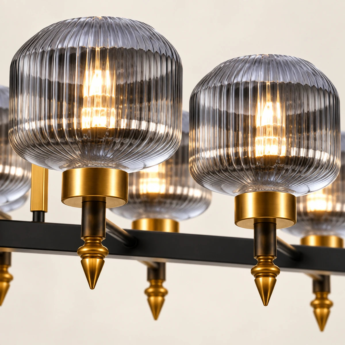 Close-up of ribbed smoke glass, antique-gold holders, pointed finials and black bar
