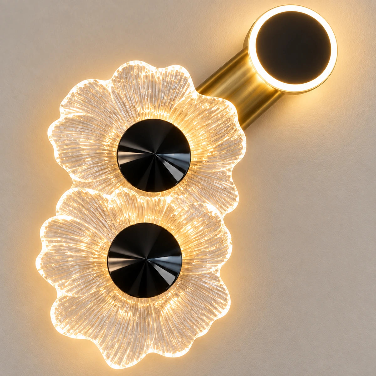 Close-up of two ruffled acrylic flowers, black centres, gold arm and halo