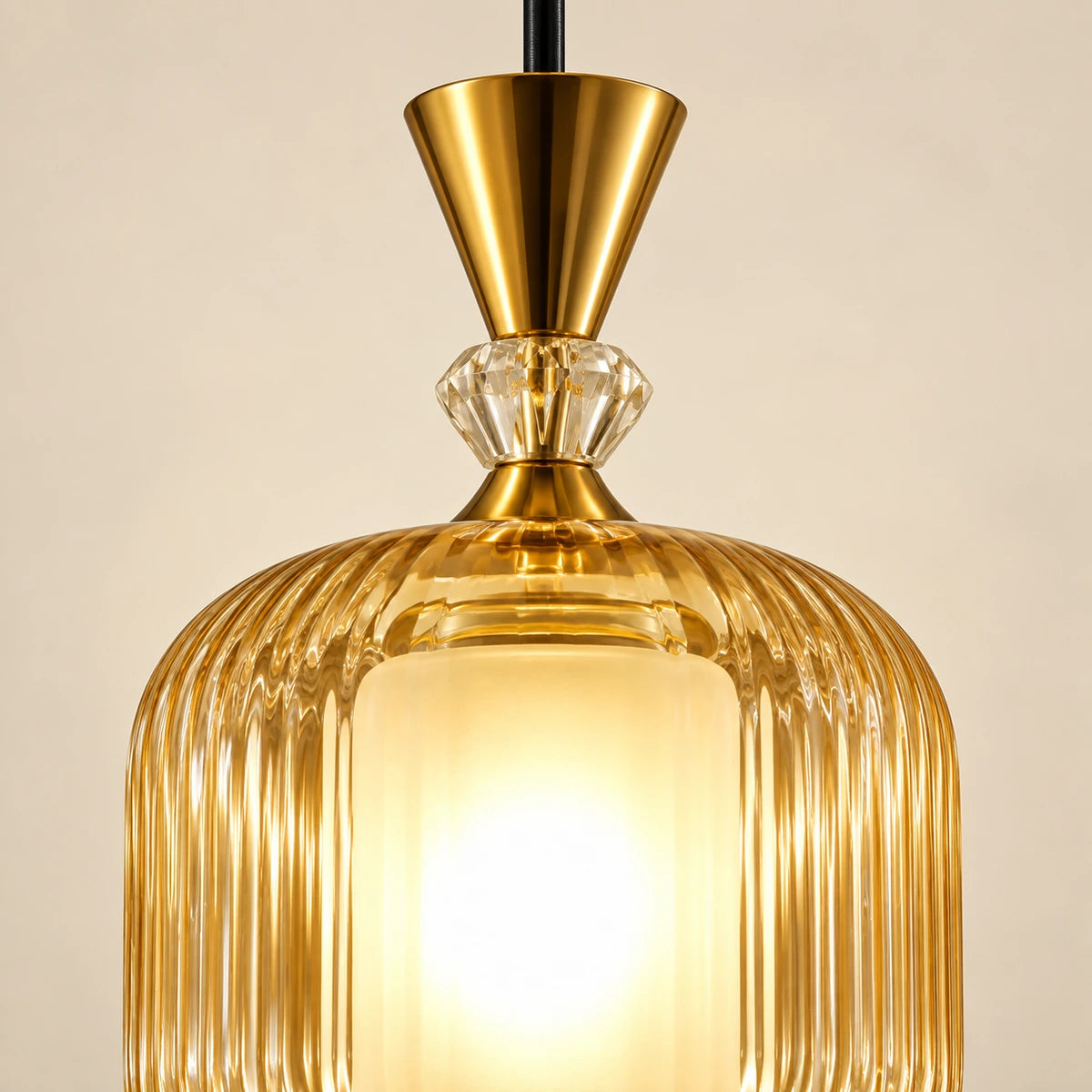 Close-up of ribbed amber glass, frosted inner cylinder and gold-tone cap