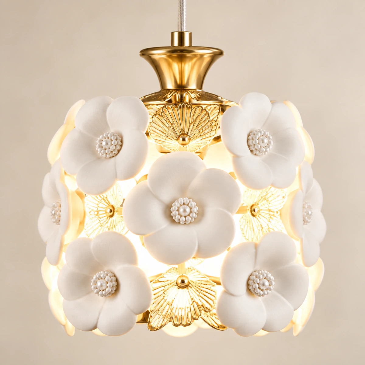 Close-up of ceramic flowers, gold-tone filigree and shade attachment