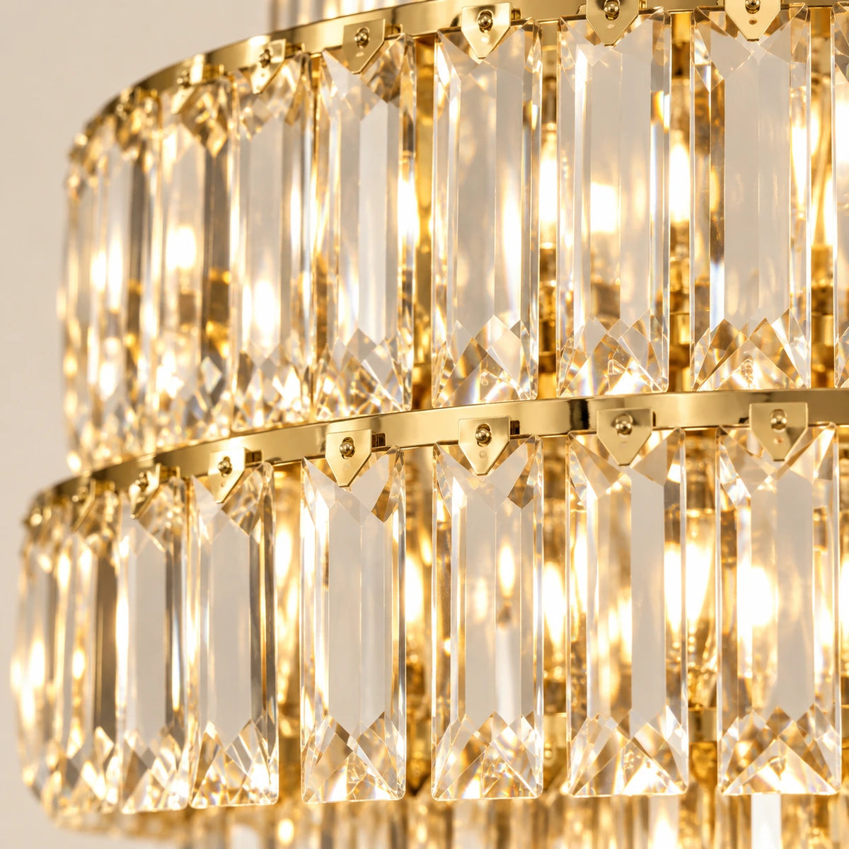 Close-up of the elongated clear crystal prisms, faceted tips and gold-toned tier rails
