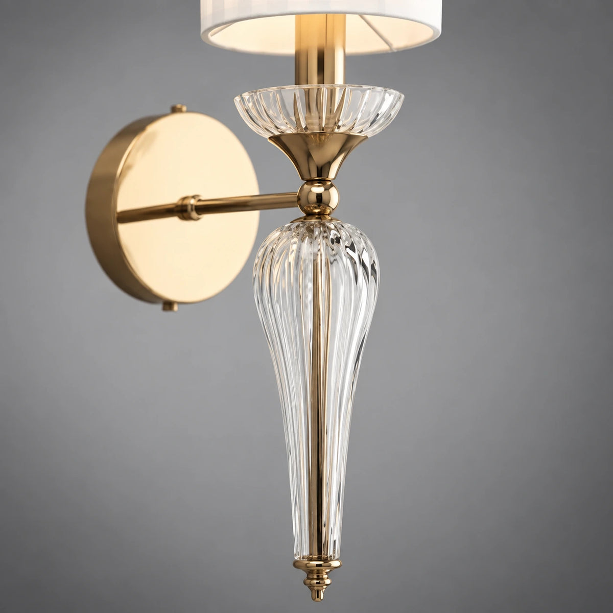 Close-up of the clear faceted tapered stem, fluted cup and warm-gold connector