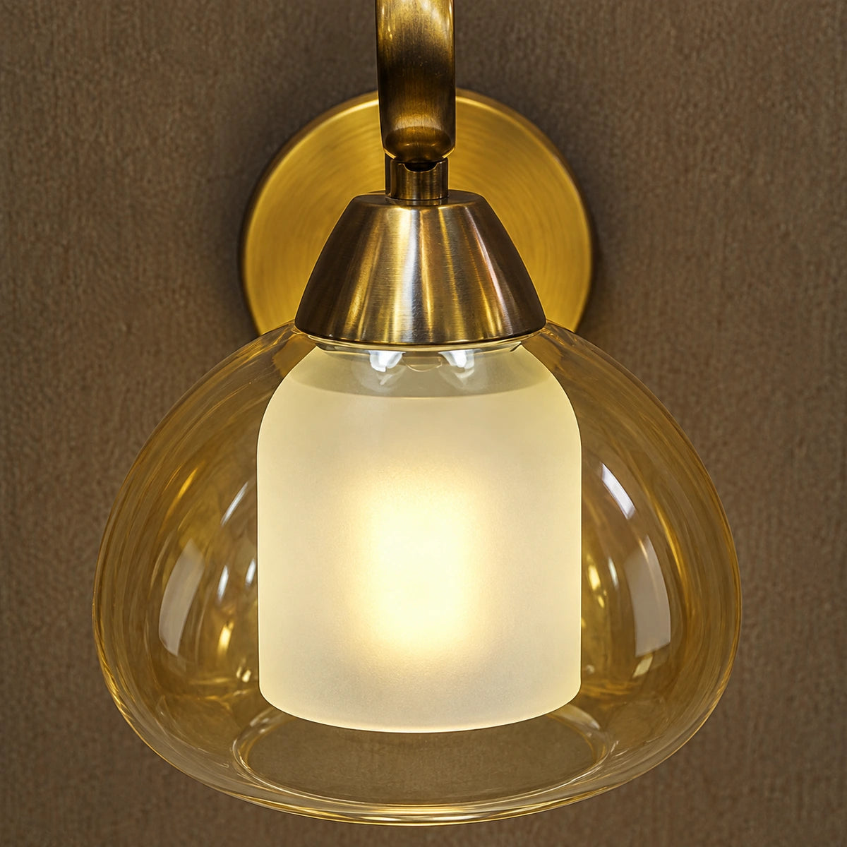 Close-up of amber outer glass, frosted inner diffuser and antique-brass connection