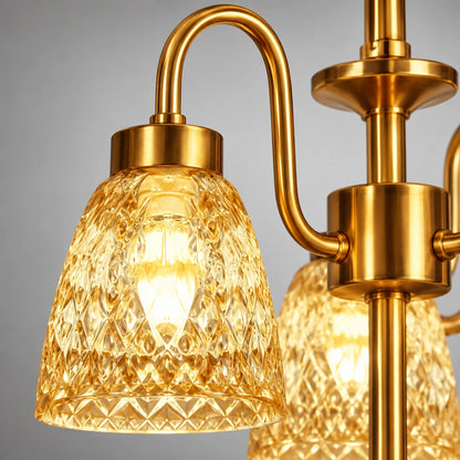 Close-up of patterned amber glass shade and curved gold arm connection