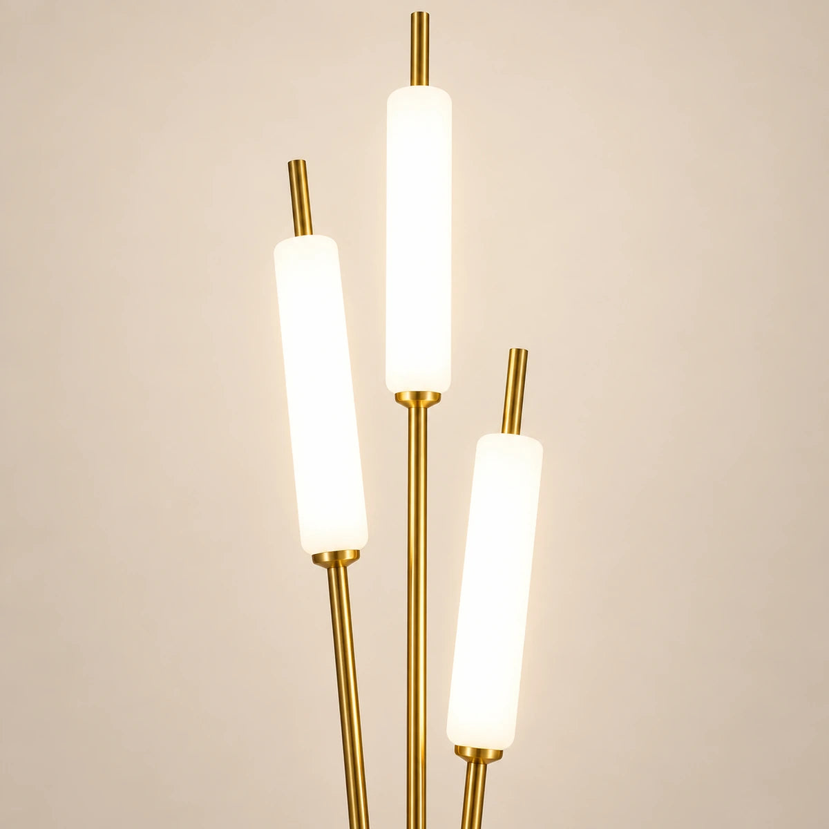Close-up of three white illuminated tubes and gold stem connections