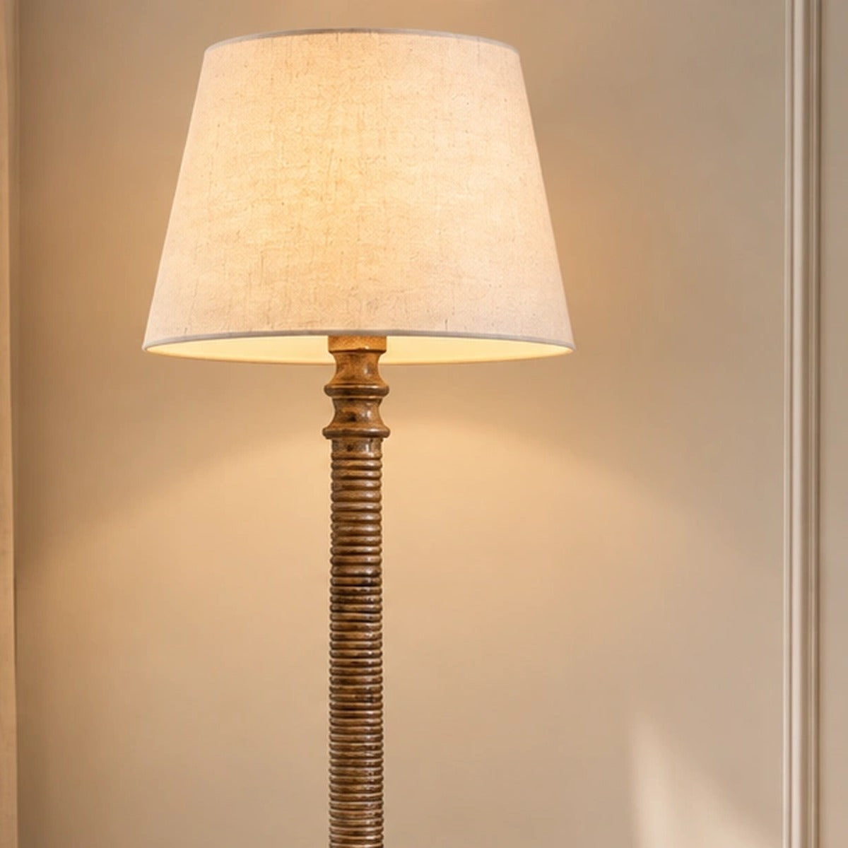 Close-up of the Lustrella floor lamp's cream shade and carved ribbed upper column