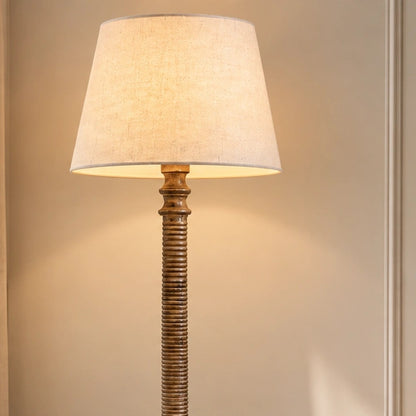 Close-up of the Lustrella floor lamp's cream shade and carved ribbed upper column