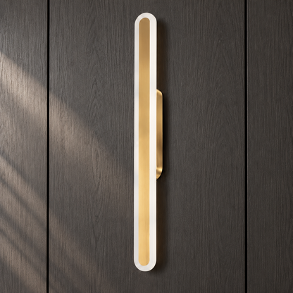 Close-up of the Luma Loop wall light's white acrylic loop, brushed-gold centre strip and compact bracket