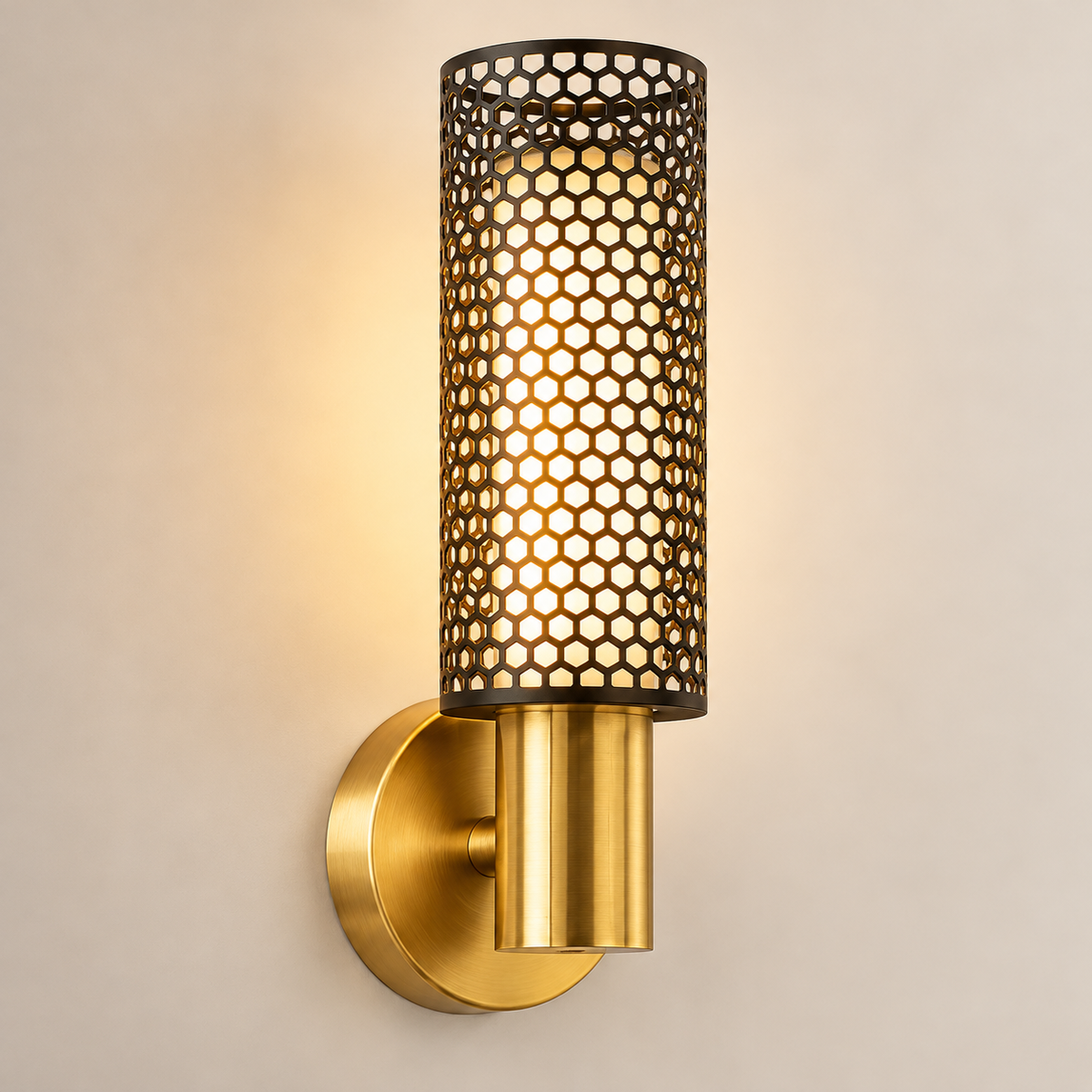 Close-up of the Vesper wall light's black honeycomb mesh cylinder, gold body and round backplate