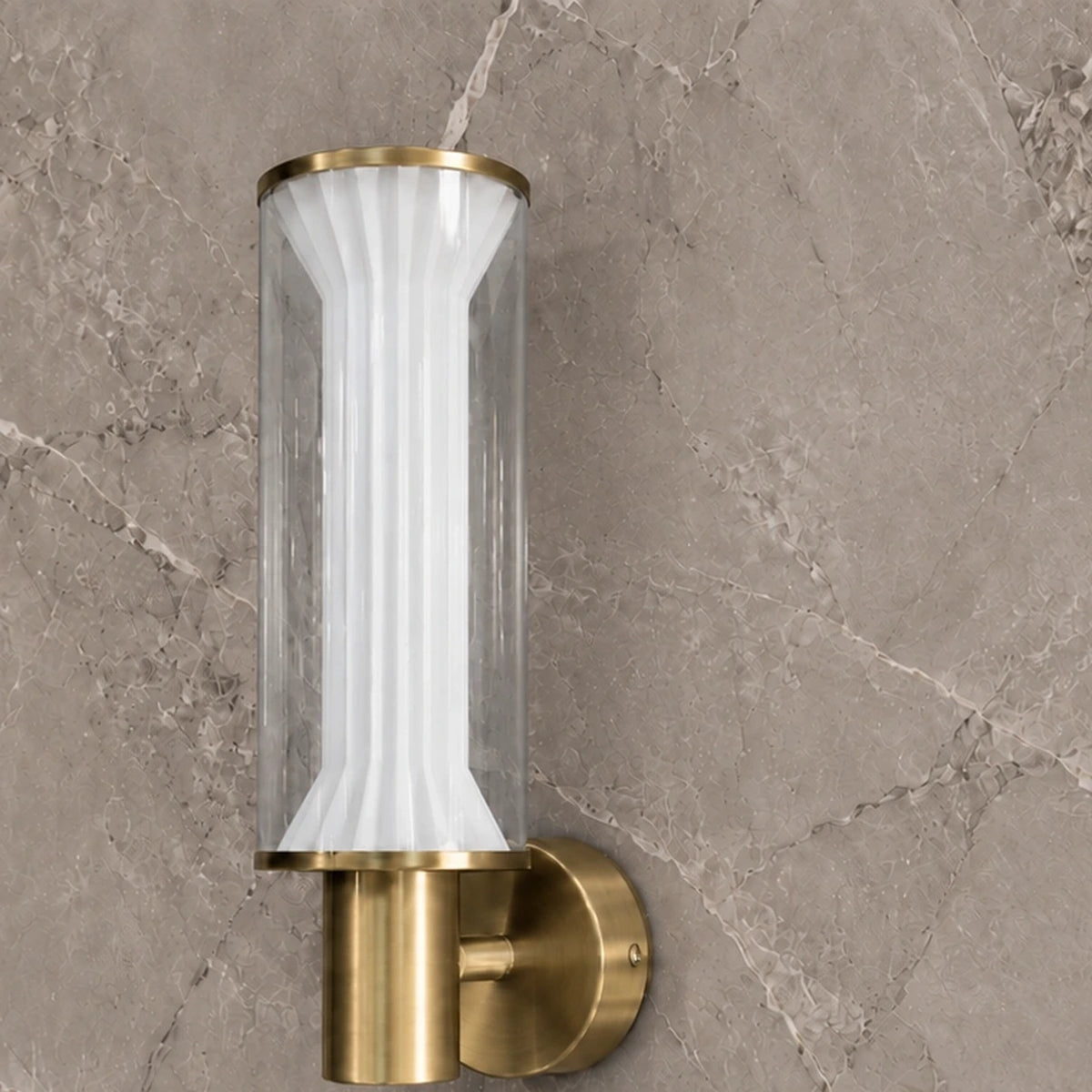 Close-up of fluted white diffuser and brushed gold wall mount