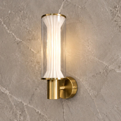 Fluted glass and gold wall light illuminated