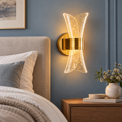 Gold hourglass wall light beside an upholstered headboard