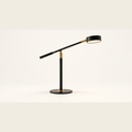 Axis black and gold task table lamp on a clean neutral studio background
